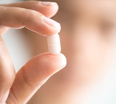 Hand holding a tablet pill