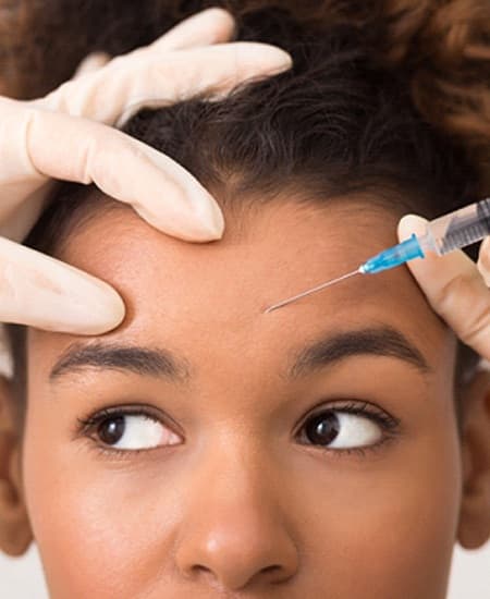 person receiving a BOTOX injection in their forehead