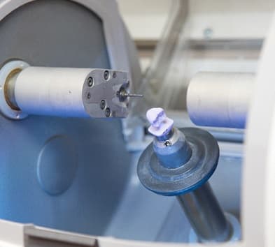 milling machine carving a dental crown