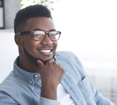 person smiling with their hand on their chin