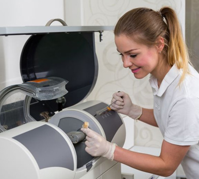 Dental team member operating a CEREC machine