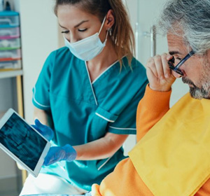 Dental team member and patient reviewing X-ray together