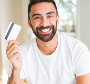 Smiling man holding payment card