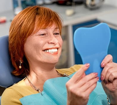 Woman looking at smile in mirror