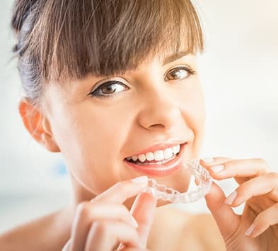 Woman placing clear aligner tray