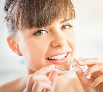 Woman placing clear aligner tray