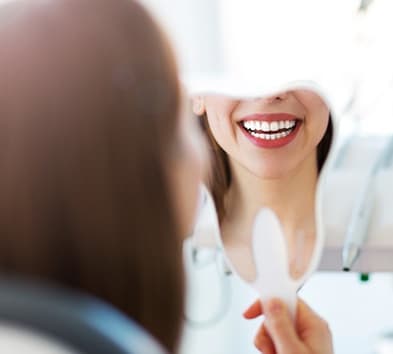 Woman looking at smile in mirror