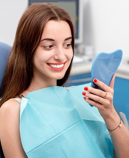 Woman looking at smile in mirror