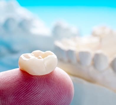 person holding a dental crown