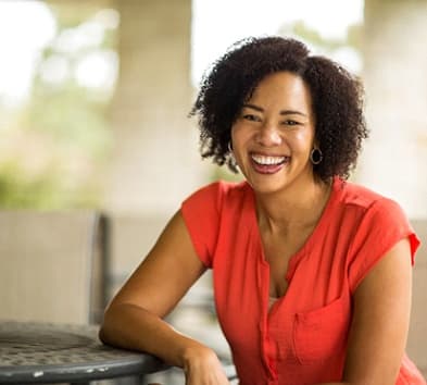 person smiling and sitting at a table