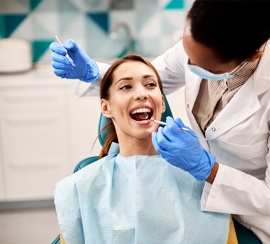 Woman in dentist’s chair undergoing treatment (Delta Dental Premier Coverage Availability & Fees 