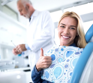 woman in the dental chair giving a thumbs-up