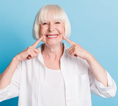 Woman pointing to her bright smile