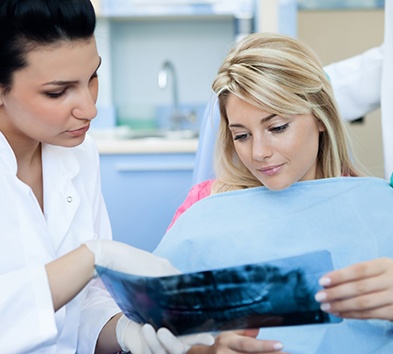 Emergency dentist in Alexandria examining an X-ray with a patient