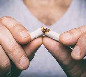 Man breaking a cigarette in half