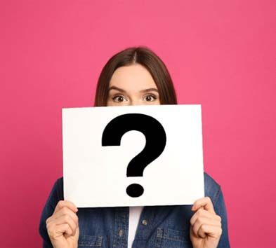 young woman holding sign with question mark