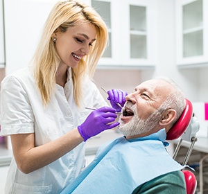 An older man visiting an implant dentist in Alexandria.