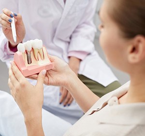 Dentist showing patient how dental implants in Alexandria work.