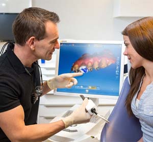 dentist showing patient digital impression on computer