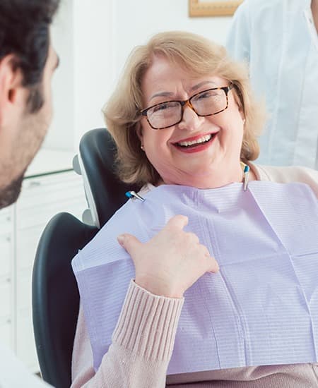 Laughing older woman in dental chair