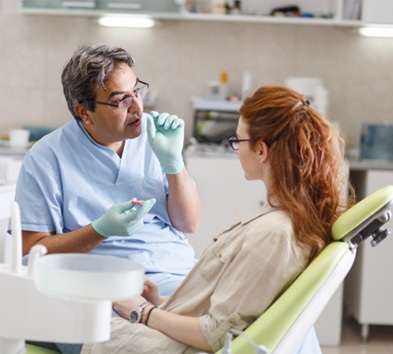 Dentist explaining dental implant salvage in Alexandria to patient    