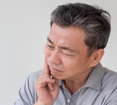 Man experiencing a failing dental implant in Alexandria.