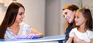 Mother and daughter checking in at reception desk