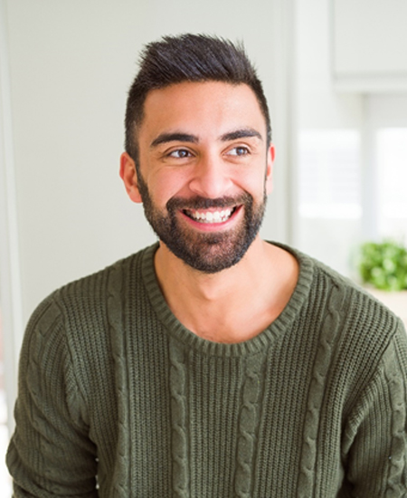 person smiling and sitting in their kitchen