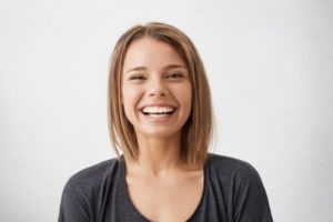 young woman laughing after getting a smile makeover 