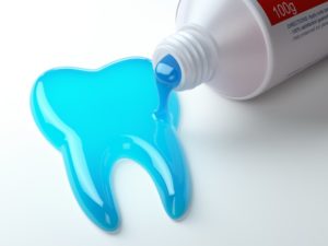 blue toothpaste spilling out in the shape of a tooth