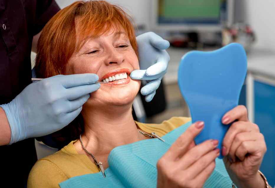Dentist fitting woman's dentures